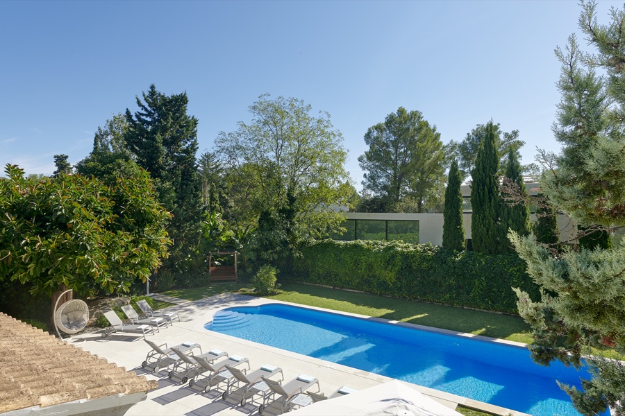 The swimming pool, sun loungers and mature garden