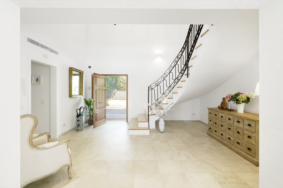 The bright hallway and staircase seen from the entrance