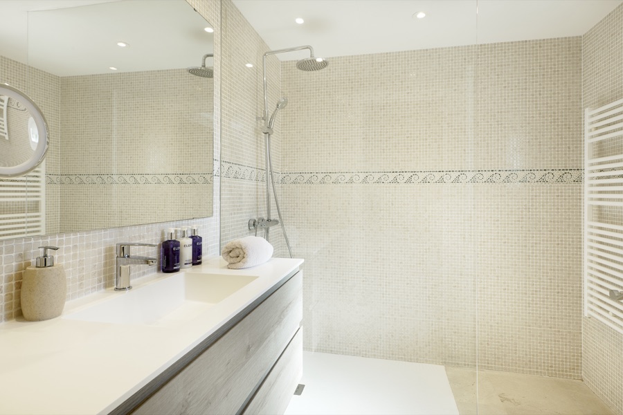 A bright en-suite bathroom with basin and walk-in shower