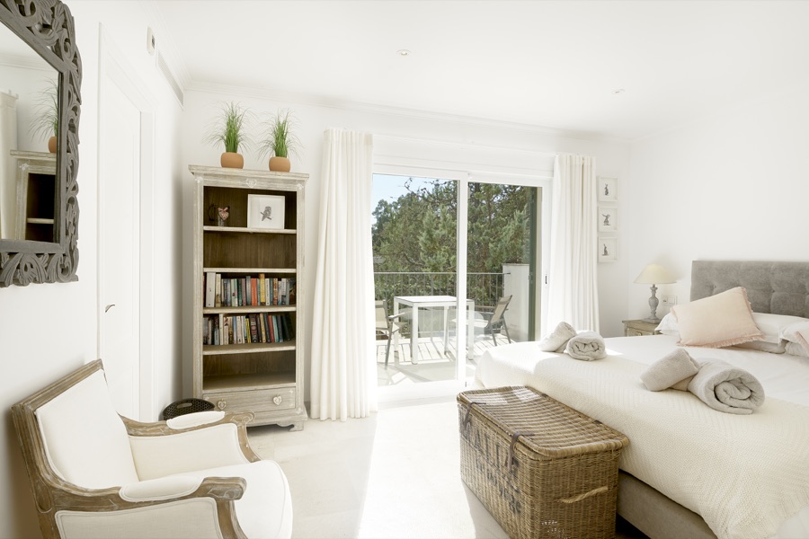 A bright upstairs bedroom with balcony doors