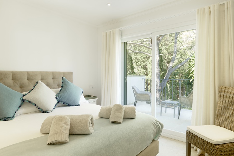 A bright double bedroom opening onto a private balcony