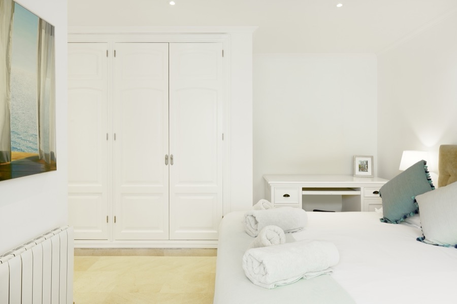 A bright double bedroom with fitted wardrobes and dressing table