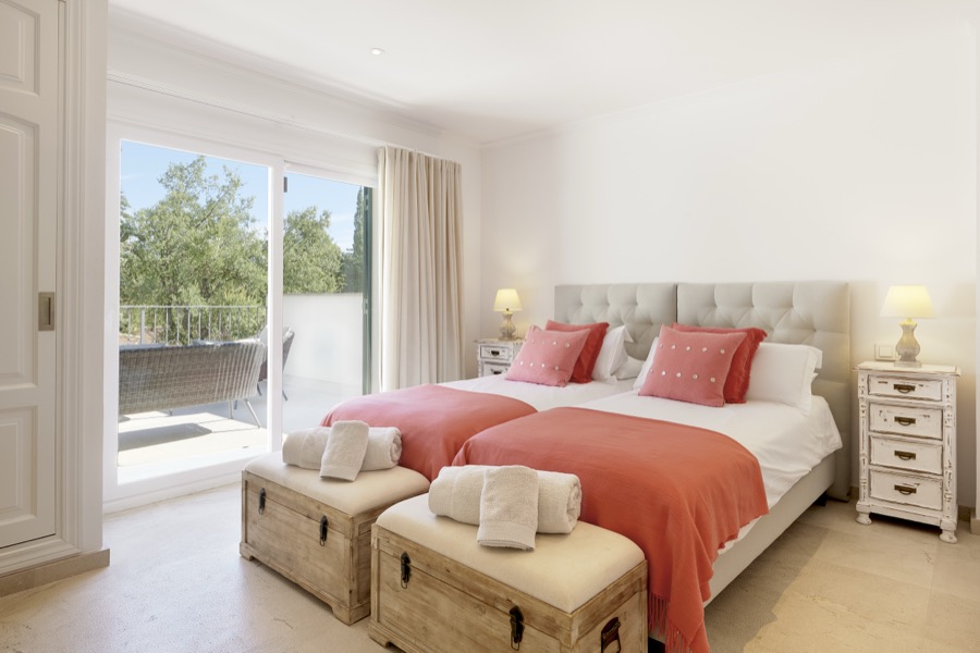 A spacious double bedroom opening onto a private balcony