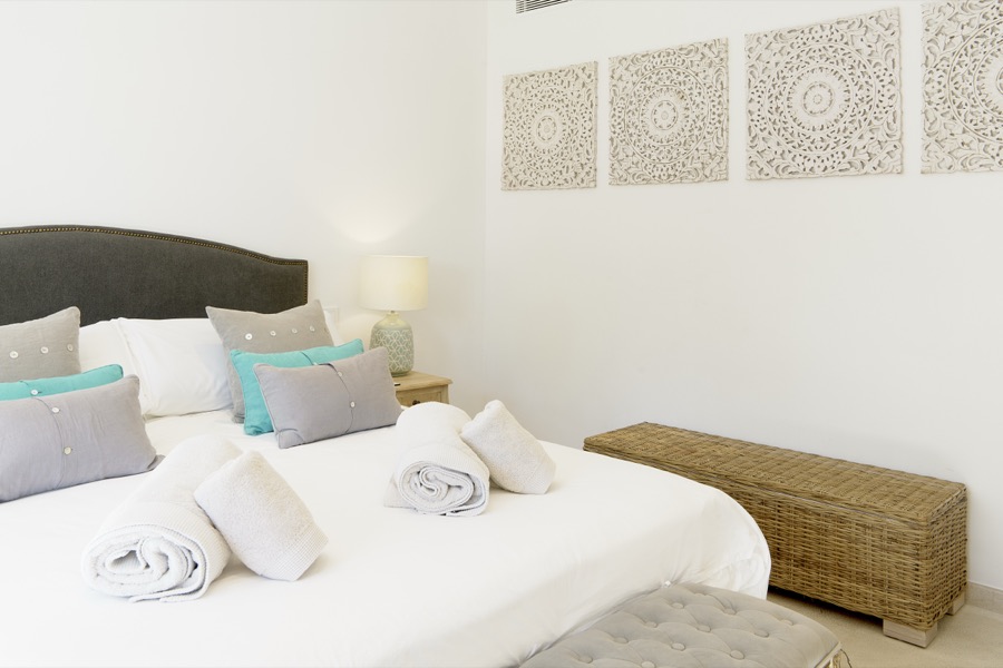 A double bedroom with upholstered bench and bedside lamps