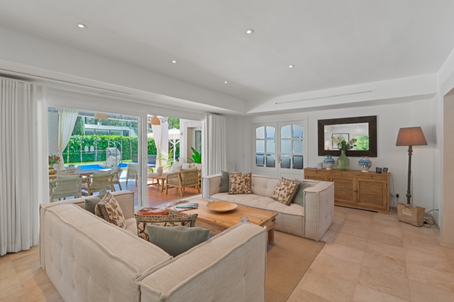 The open-plan living room with doors onto the pool terrace