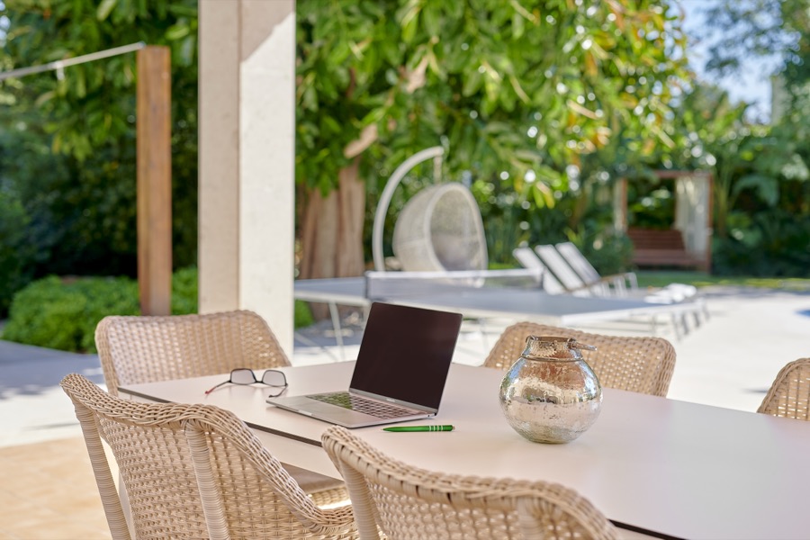The shaded terrace dining table overlooking the pool and garden